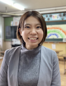 写真:教室内で笑顔で立つ女性